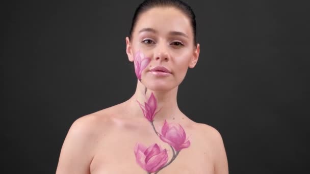 Test Art: nő festett magnólia az arcán és bordák. Virág a testen. Portré fekete háttér