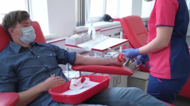 Ukrayna, Kyiv, 27 Mart 2020. Kan Bağış Merkezi. Lastik eldivenli hemşire donörden kan örneği alıyor. Donör Günü konsepti Covid 19 salgını