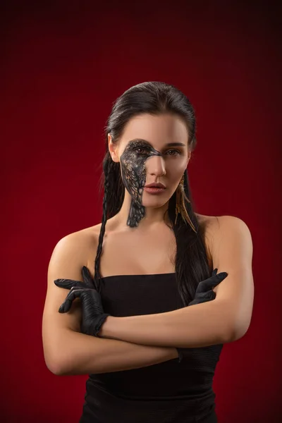 Portret młodej zmysłowej brunetki z czarnym krukiem ptasiej sztuki na twarzy. Kobieta w czarnych rękawiczkach — Zdjęcie stockowe