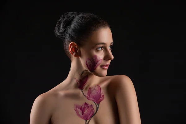 Cute girl with dark hair, body art paintings on neckline and face, naked shoulders, painting magnolia flowers, make up model — Stock Photo, Image