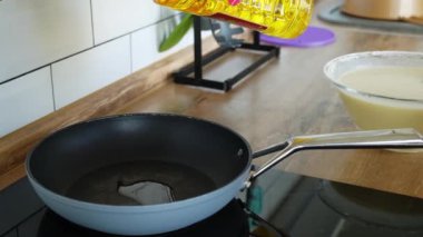 Aşçı, kız eli lezzetli yemek pişirmek için siyah tavaya sarı ayçiçeği yağı döker. İçerik sosyal ağları restoran kafe lezzetli yemekler eve servis ediliyor. gözleme pişirmek