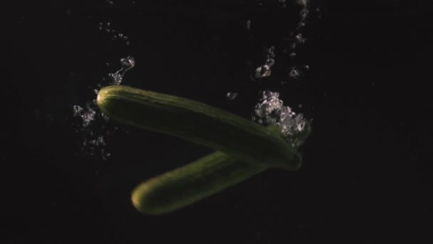 Siyah Arkaplana Karşı Suya Düşen Yeşil Salatalıklar Yavaş Çekim — Stok video