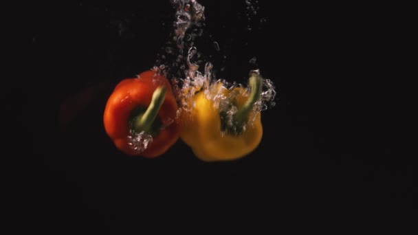 Hele Rode Uellow Paprika Vallen Het Water Langzame Beweging Zwarte — Stockvideo