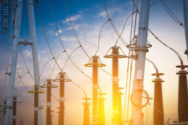 distribution electric substation with power lines and transformers, at sunset