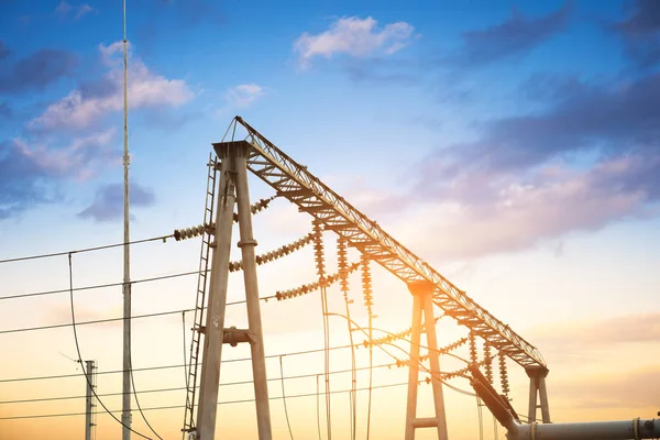 Impression network at transformer station in sunrise, high voltage up to yellow sky take with yellow tone, horizontal frame