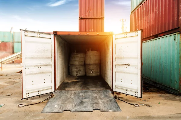 Forklift truck lifting cargo container in shipping yard or dock yard against sunrise sky with cargo container stack in background for transportation import,export and logistic industrial concept