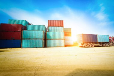 Forklift kamyon kargo konteyner nakliye bahçede kaldırma veya bahçesinde gündoğumu gökyüzü ile kargo Konteyner Taşımacılık ithalat, ihracat ve lojistik sanayi kavramı için arka plan yığınında karşı dock