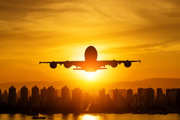 Passagiersvliegtuig is landing tijdens een prachtige zonsopgang. — Stockfoto