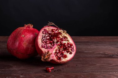 Siyah zemin üzerinde tahta bir tahtanın üzerindeki nar.