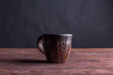 Kahverengi kil kahve fincanları ve ahşap bir masada sıcak renklerde lezzetli çikolatalı kurabiyeler.