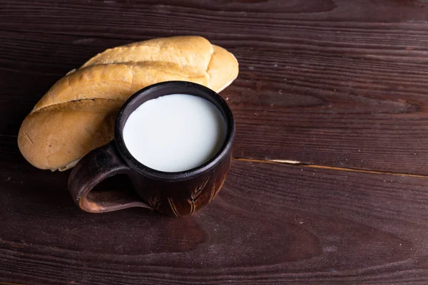 Croissant with milk on a wooden table — Stock Photo, Image