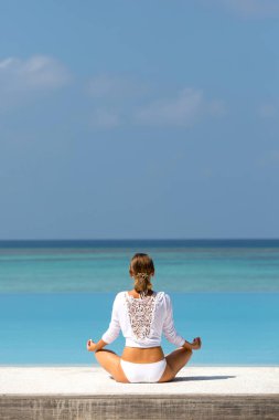 Beyaz pratik yoga sahilde güzel kadın. Maldivler