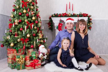 Noel ve yeni yıl kutlama. Mutlu genç ailesi ne kadar da bir şömine ile Noel ağacı