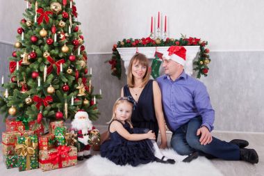 Noel ve yeni yıl kutlama. Mutlu genç ailesi ne kadar da bir şömine ile Noel ağacı