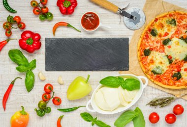 Malzemeler ve kopya alanı karanlık bir plaka üzerinde pizza
