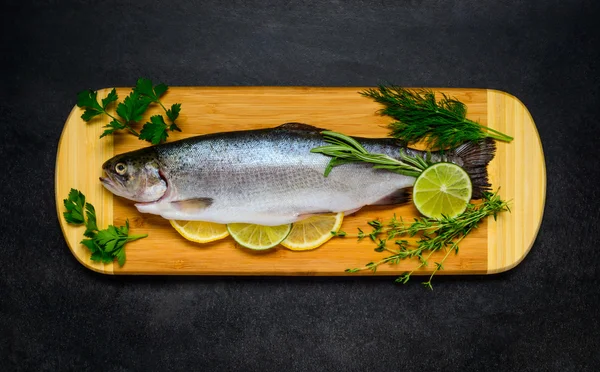 Pescado crudo de trucha preparado para cocinar y sobre tabla de cobre de madera —  Fotos de Stock