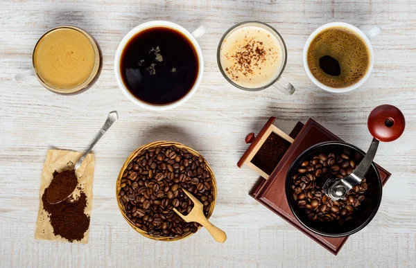 Kaffekoppar med bönor, kvarn och marken — Stockfoto