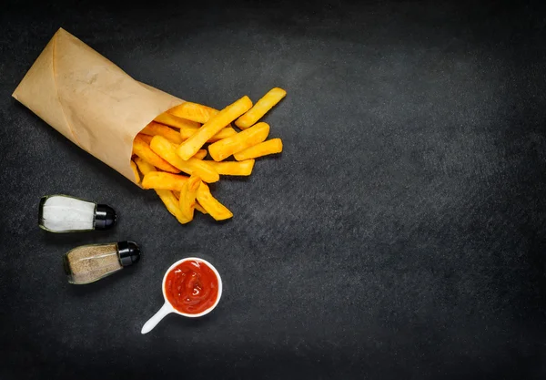 Papieren zak met patat en specerijen op kopie ruimte — Stockfoto