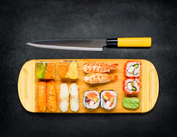 Cuchillo japonés con rollos de sushi y sashimi —  Fotos de Stock