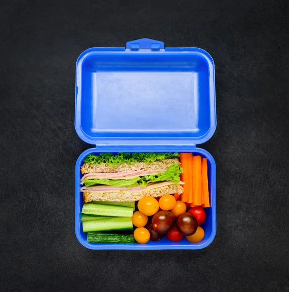 Blauwe Lunchbox met Sandwich en groenten — Stockfoto