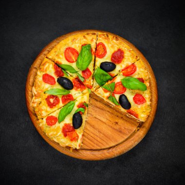 Pizza koyu arka plan üzerine dilimlenmiş