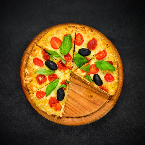 Pizza in Scheiben auf dunklem Hintergrund — Stockfoto