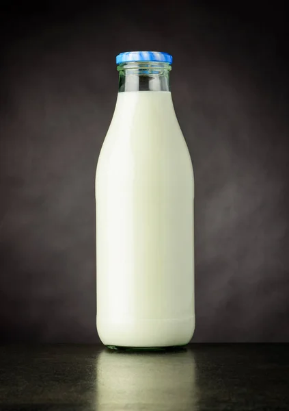 Flaschenmilch auf dunklem Hintergrund — Stockfoto