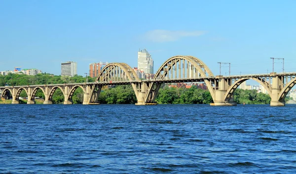 Železniční klenutý most přes řeku Dněpr s výhledem na město Dnipro Ukrajina — Stock fotografie