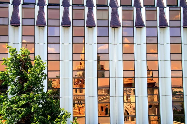 Ancient castle Fishermen's bastion reflected in the mirror  facade of a building. — Stock Photo, Image