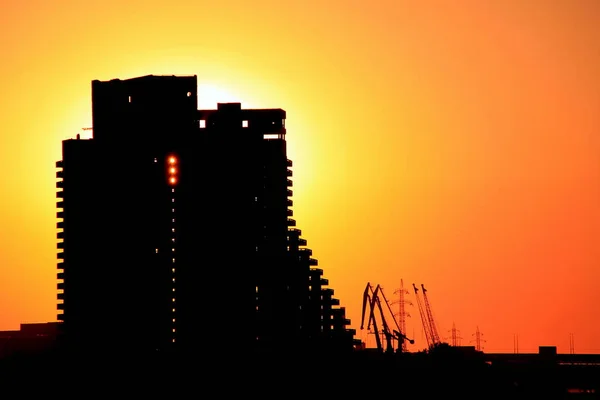 Silhouette of building and port cranes in   Dnepr city at sunset. Ukraine