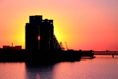 Silhouette bir çok katlı bina ve gün batımında Dnepr şehirde bir köprü