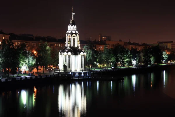 Vacker kyrka med lysande nattetid, ljus reflekteras i vattnet. Utsikt över staden Dnepr, (Dnepropetrovsk, Dnipro, Dnipropetrovsk). Ukraina, — Stockfoto