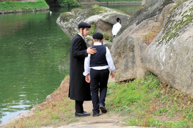 2 chasid erkek geleneksel giysiler içinde Parkta yürümek.