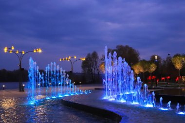 Manzara parkında güzel bir havuz, gece manzaralı ışıklandırma ile güzel bulutların arka planında. Ağaçlar suya yansıyor. Büyük şehirde yaratıcı tasarım. Dnipro, Dnepropetrovsk, Ukrayna