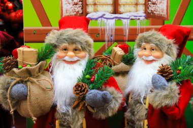 Gülen kırmızı Noel Baba, en sevdiği yeni yıl oyuncakları, süslemeler ve hediyeler, en iyi olumlu duygular. Noel şenliği kış ticareti, alışveriş. Oyuncak Mağazası Fuarı