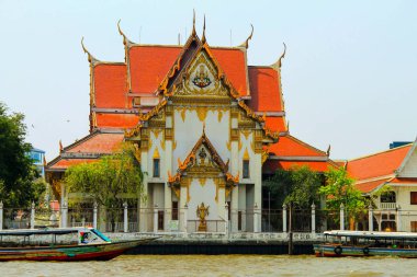 Bangkok 'taki renkli eski Budist tapınağı. Nehrin üzerinde turuncu kiremitli çatısı var. Tayland, Asya.