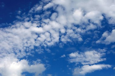 Güzel beyaz kümülüs, parlak mavi gökyüzüne karşı yağmur bulutları. Resim gibi, fantastik bulutlar. Yaz için sade manzara, bahar posteri