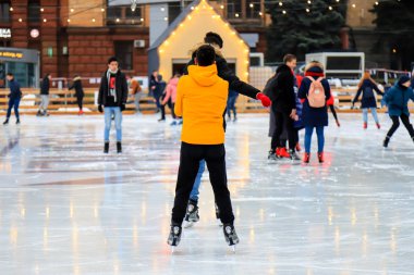 Winter ice rink. Happy boys have fun on ice. Active family sport during Christmas winter break. School sports clubs. Dnipro city, Dnepropetrovsk, Ukraine