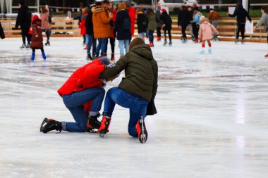 Gençler buz patenine gider ve buz pistine düşer. Spor sakatlığı, bacak ağrısı, yılbaşı tatilinde spor yaparken kırılma. 2022 Dnipro, Dnipropetrovsk, Ukrayna