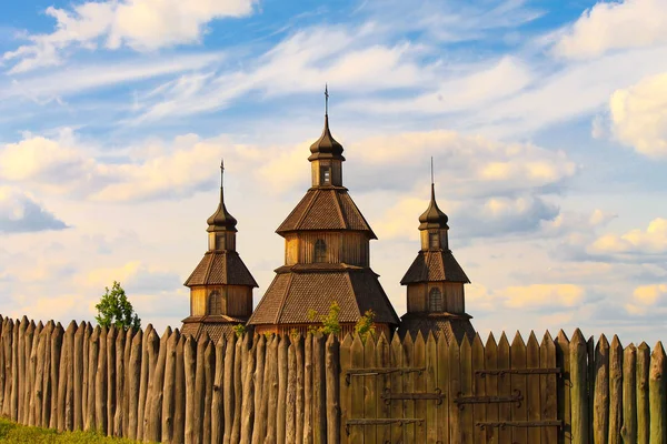 Bella vecchia chiesa d'epoca in legno il giorno di Pasqua, recinzione in legno e cancelli. Chiesa cristiana ortodossa di Zaporizhzhya cosacchi sul Khortytsya nello Zaporozhye ucraino al tramonto. Ucraina — Foto Stock