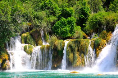 İlkbahar veya yaz aylarında Krka şelaleleri, Lakes Peyzaj Parkı, Hırvatistan 'daki büyük taşlar arasında pitoresk bir şelale. Hırvat şelaleleri, dağlar ve doğa.
