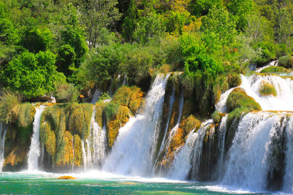 A picturesque cascade waterfall among large stones in the Krka Landscape Park, Croatia in spring or summer. The best big beautiful Croatian waterfalls, mountains and nature.