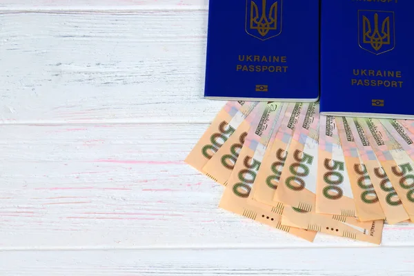 ウクライナの碑文とウクライナの外国の生体パスポート 白い木製の背景にグリブノートを持つウクライナのパスポート 旅行の概念 — ストック写真