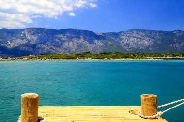 Türkiye 'de Bodrum ve Marmaris yakınlarındaki pitoresk deniz plajı. Güzel deniz arka planı, berrak turkuaz suyu ve dağları olan körfez.