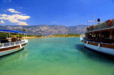 Yaz mevsimi geçmişi. Bodrum ve Marmaris yakınlarındaki Türk adasının yanındaki pikoresk turkuaz sularda eğlence tekneleri duruyor. Seyahat ve tatil, Türkiye