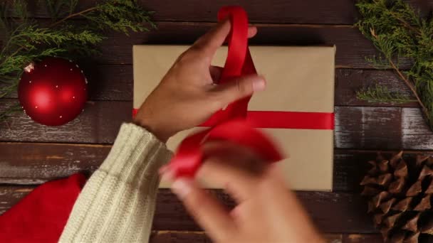 Top view hands wrapping christmas presents at wooden desk from above — Stock Video