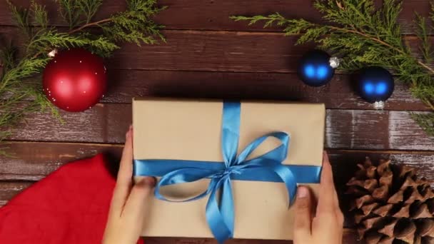 Top view hombre desenvolviendo regalos de Navidad en manos de escritorio de madera desde arriba — Vídeo de stock