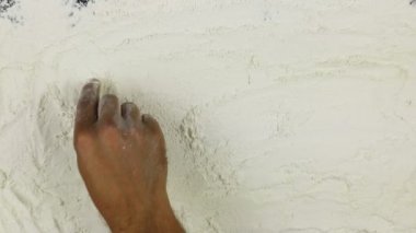 Genç adam bir kelime çerezleri üzerinde beyaz un yazıyor