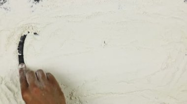 Genç adam bir kelime gluten beyaz un üzerinde yazıyor