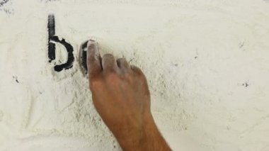 Genç adam beyaz un sınıf pişirme bir kelime yazıyor